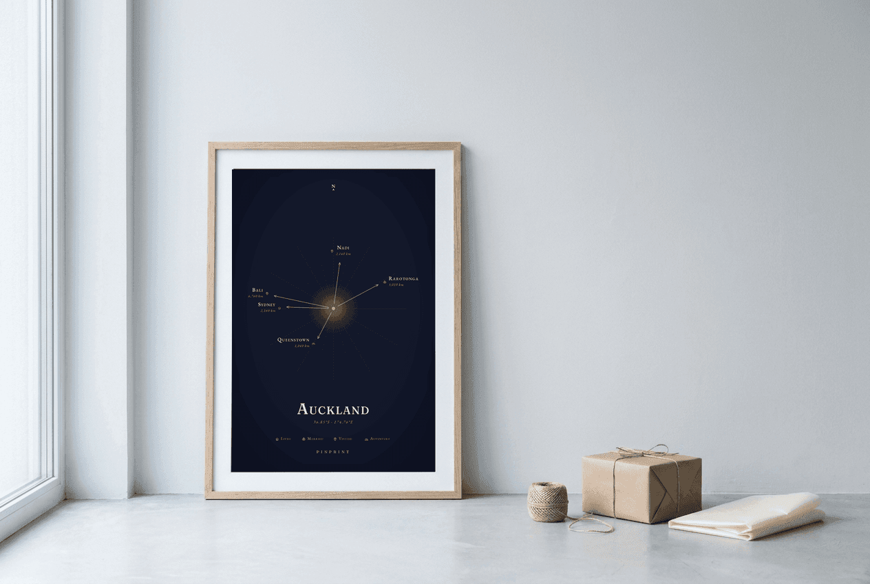 Framed celestial Heartbound Maps of Auckland leaning against an ivory wall next to kraft wrapping paper and twine